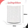 A white quilted blanket is shown with dimensions indicated by text and lines. Produktbild-Vorschau