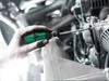 A person's hand is using a screwdriver to work on a mechanical device. Produktbild-Vorschau