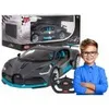 A boy is standing next to a remote-controlled car and its packaging. Produktbild-Vorschau
