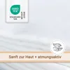 A close-up of white muslin fabric with a certification label and marketing text. Produktbild-Vorschau