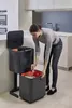 A woman is sorting waste in a modern kitchen. Podgląd zdjęcia produktu