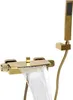 A gold-colored bathtub faucet with a waterfall spout and a handheld showerhead. Náhled obrázku produktu