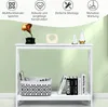 A white console table with decorative items and storage on it, set against a light green wall. Podgląd zdjęcia produktu