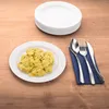 A plate of potato salad is shown next to a stack of white plates and cutlery on a wooden table. Produktbild-Vorschau