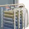 A multi-tiered hanger holding several pairs of pants and shirts hanging on clothes hangers. Produktbild-Vorschau