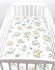 A crib with a fitted sheet featuring a jungle animal print. Produktbild-Vorschau
