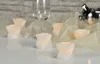A set of LED candles arranged on a white surface with sheer fabric and a wine glass in the background. Produktbild-Vorschau
