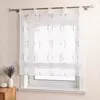 A sheer white curtain with a gray embroidered wavy pattern hangs on a window. A small vase with lavender is on a wooden surface to the left. Produktbild-Vorschau