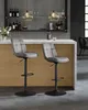Two gray bar stools are placed in front of a bar counter in a modern home or commercial setting. Produktbild-Vorschau