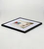 A framed picture with a red poppy on a blue background, displayed on a white surface. Produktbild-Vorschau