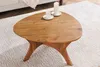 A wooden coffee table with two candles on it, placed on a white rug. Produktbild-Vorschau