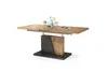 A modern dining table with a lift-top mechanism and a unique pedestal base, decorated with small vases of flowers and a magazine. Produktbild-Vorschau