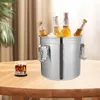 A stainless steel ice bucket filled with beer bottles sits on a wooden table next to a glass of whiskey. Produktbild-Vorschau