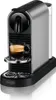 A silver and black Nespresso coffee machine with a cup of espresso. Podgląd zdjęcia produktu