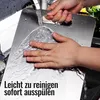 Hands washing a metal cutting board under running water in a sink. Produktbild-Vorschau