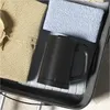 A black electric kettle is placed inside an open suitcase, surrounded by folded clothes. Produktbild-Vorschau