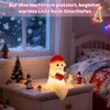 A cute ghost lamp is sitting on a nightstand next to a Christmas tree and other decorations, with a snowy window in the background. Produktbild-Vorschau