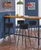 Four black bar stools are arranged around a wooden table with a blue wall in the background and a wine rack on the wall. Podgląd zdjęcia produktu