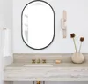 A modern bathroom vanity with a mirror, sink, faucet, and decorative items. Produktbild-Vorschau