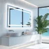 A modern bathroom with a large LED mirror, double sinks, and a tropical plant. Podgląd zdjęcia produktu