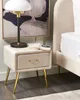 A bedside table next to a bed, with a lamp and books on top. Náhľad obrázku produktu