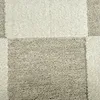 A close-up view of a carpet with a checkered pattern. Podgląd zdjęcia produktu