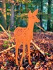 A metal deer fawn garden stake stands in a forest floor covered with fallen autumn leaves. Produktbild-Vorschau
