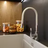 A kitchen sink with a beige faucet and jars of nuts in the background. Anteprima dell’immagine prodotto