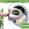 A hand is holding a pet accessory, about to place it into a washing machine. Produktbild-Vorschau