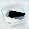 A smartphone is placed in a glass container filled with silica gel beads. Podgląd zdjęcia produktu
