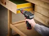 A person is using a cordless drill to attach a drawer slide to a wooden workbench. Produktbild-Vorschau