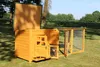 A wooden chicken coop with an attached run is set up on a grassy lawn. Produktbild-Vorschau