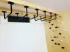 A ceiling-mounted pull-up bar and a climbing wall are shown in a room. Voir les images du produit
