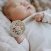 A close-up shot of a baby sleeping with a pacifier in its mouth. Produktbild-Vorschau