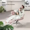 A man is sitting in a pink office chair in a yard, holding a small dog. Podgląd zdjęcia produktu