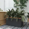 A rectangular planter filled with lush green plants sits on a wooden deck, with a woven storage unit to the left and bamboo plants in the background. Náhľad obrázku produktu