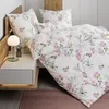 A bedroom scene with a bed made with floral bedding. Voir les images du produit