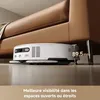 A robot vacuum cleaner is shown cleaning under a brown leather couch. Produktbild-Vorschau