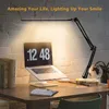 A desk setup with a laptop, books, and a desk lamp. Produktbild-Vorschau