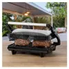 A Bomann contact grill is shown outdoors on a wooden table, grilling two steaks. Produktbild-Vorschau