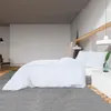A bedroom scene with a bed made with white bedding. Produktbild-Vorschau