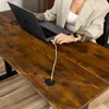 A person is using a laptop on a wooden desk with a cable plugged into the laptop and routed through a desk grommet. Náhled obrázku produktu