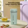 A portable kettle and a cup of tea are on a table, with cookies in the foreground. Produktbild-Vorschau