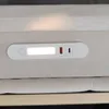 A close-up view of a white LED light strip with USB and USB-C ports integrated into the side of a beige upholstered bed frame. Anteprima dell’immagine prodotto