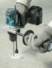A person wearing gloves is using a Makita hammer drill to drill a hole in a concrete surface. Anteprima dell’immagine prodotto