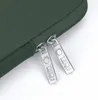 A close-up view of the zippers on a green laptop bag. Anteprima dell’immagine prodotto
