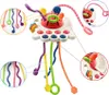 A collage of images showing a multi-colored sensory toy with various textures and dangling strings, along with close-up views of its features. Náhľad obrázku produktu