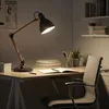 A desk with a lamp, books, and a chair, suggesting a study or work environment. Náhled obrázku produktu