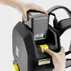 A person's hands are shown interacting with a Kärcher professional backpack vacuum cleaner, specifically inserting or removing a battery pack. Produktbild-Vorschau