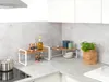 A kitchen counter with spice racks, bottles, and a plant. Anteprima dell’immagine prodotto